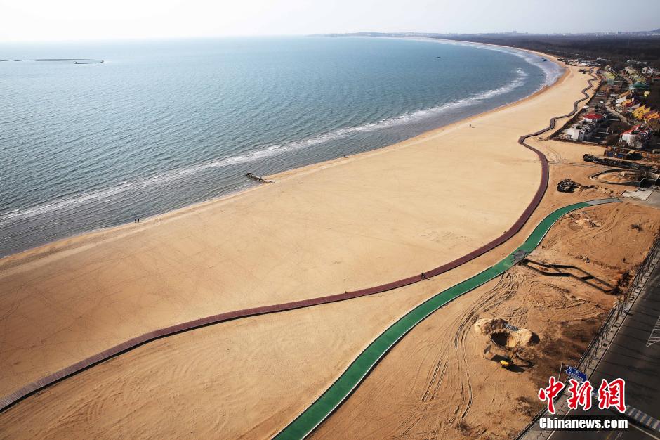 3月13日，秦皇島萬(wàn)米臨海沙灘木棧道。據(jù)了解，該木棧道全長(zhǎng)約4200米，與北戴河區(qū)原有的7500米木棧道對(duì)接后全線總長(zhǎng)度1.17萬(wàn)米，整個(gè)木棧道東起秦皇島體育基地游船碼頭，西至北戴河濕地公園，呈波浪形蜿蜒10.4公里海岸線。 中新社發(fā) 曹建雄 攝 CNSPHOTO